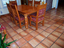 Why Are There Color Variations in Saltillo Tile?  Saltillo tile usually varies in colour and shape, however the majority range from in varying hues of reds, oranges and yellows. These beautiful floor tiles are shaped by pressing quarried clay with a wooden frame (super), or could be carving out the desired shape (regular). Depending on the raw tile's placement among other tiles at the time of firing, its colour ranges from yellow to a rich orange.  Since each piece of standard Saltillo tile is actually made individually by hand with no modern machinery involved, most pieces will have that individual character. The tile is primitive. There are irregularities. You will find small chips, cracks, and bumps. These imperfections merely add character and rustic quality to the floor. If you are lucky, you might even find a few animal footprints in your tile!  With regard to color, lets talk about process a little since this accounts for the major changes you may see from one firing to the next.  The tiles are stacked in the caves (kilns) on end which may slightly overlapp so they don't fall over. Then, before firing, the opening to the kiln is sealed with clay to prevent heat from escaping. The fire is started at the bottom of the cave and fuel is added to increase the heat until the proper temperature is reached. As you know, fire will not burn without oxygen, and at sometime during the firing process all of the available oxygen in the atmosphere in the cave is used up. At that point the flame then seeks the next available source of oxygen (which it finds in the form of iron oxide in the clay tile) and burns it, flashing the exposed surfaces of the tile. The light buff color in the tile is the area that was flashed; the peach color in the tile is the area, which is shielded from the flame by other tiles. You may hear many different stories about different types of fuel used in the firing of Saltillo tile. The original source of heat used for firing Saltillo tile was burning rubber tires. Most of the time, wood is now used to start the process. In the past few years, a variety of fuels have also been used, such as propane, diesel, crude petroleum, etc. The type of fuel used for firing does not directly affect the color of the tile. Heat is heat, much like a gas or electric stove.   The color of the tiles may vary somewhat due to:  Different ways the tile is stacked in the kiln.  The way in which the flame/heat is controlled inside the kiln.  Depending on if a color additive is added to the clay during the manufacturing process   Whether a slight  green hue is apparent from the firing process.  Regardless of your choice of Mexican tile, be it Saltillo, Mission, Talavera or other varieties, you can't beat these tiling options for creating a traditional, southwestern atmosphere in any room of your house. Our job is to provide a professional installation and then keep them beautiful.  Call us today for an estimate on installing, cleaning or restoring the Mexican Tile in your home or business. Keith Clay Floors is happy to assist you with any questions you may still have about Saltillo tile in general. Call us today, you will be so glad you did.  World Class Craftsmanship. Reasonable Prices. Call Today: 972-463-6604